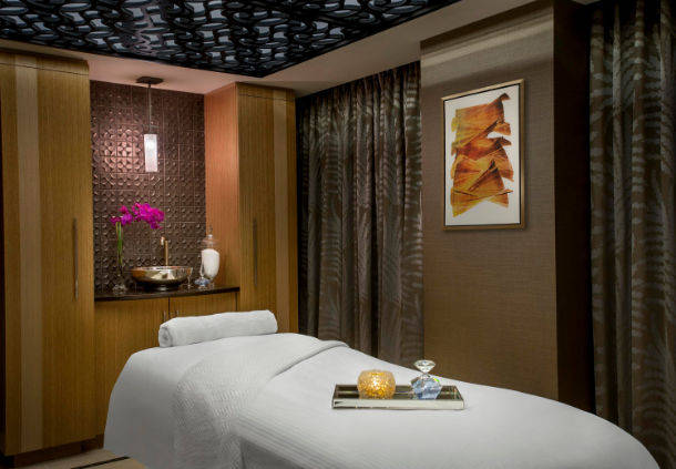 a massage room with a bed and a sink