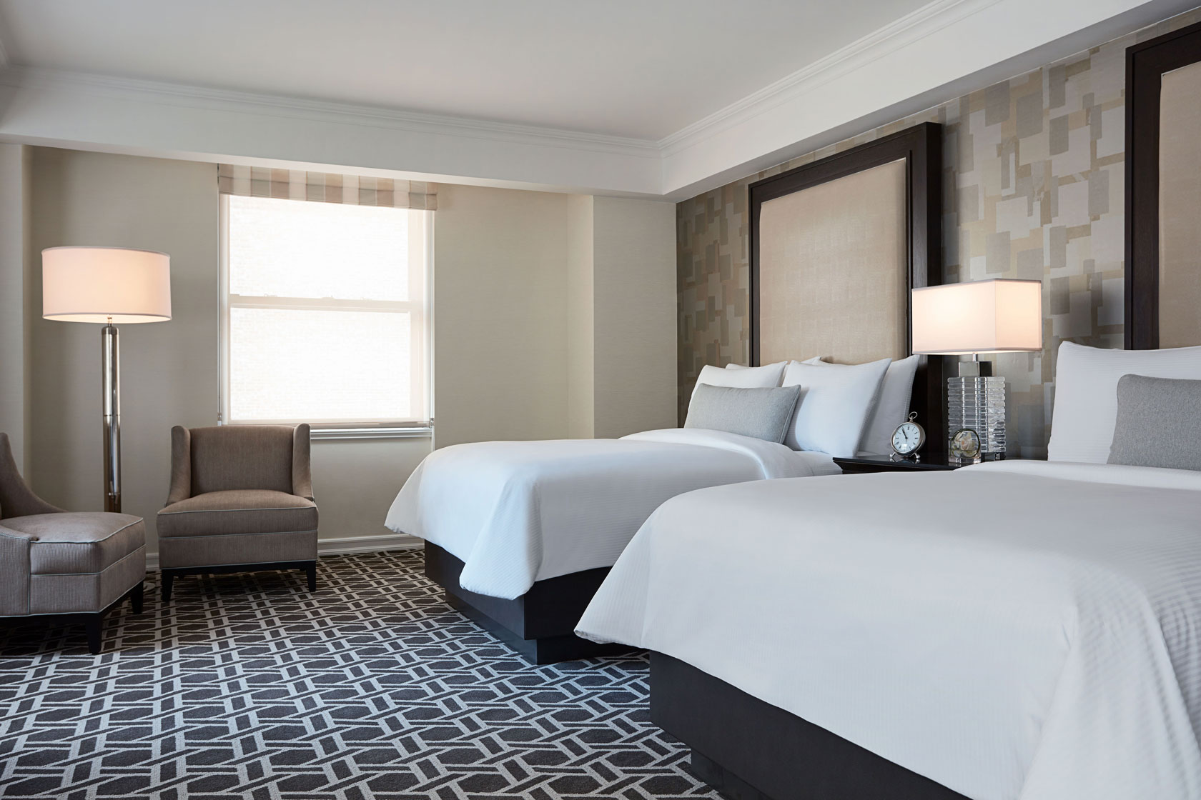 a room with two beds and a chair
