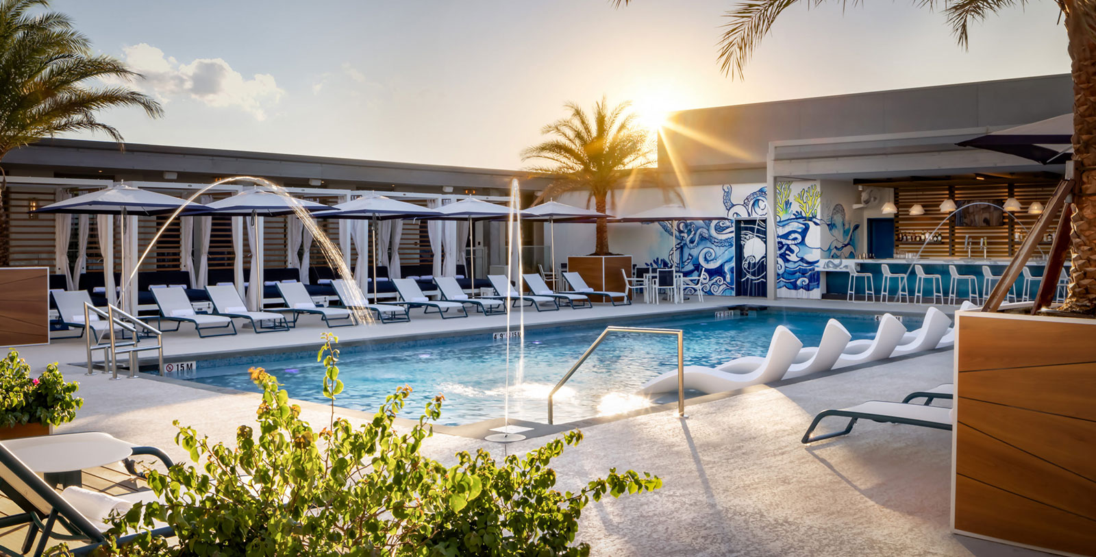 a pool with water jets and umbrellas
