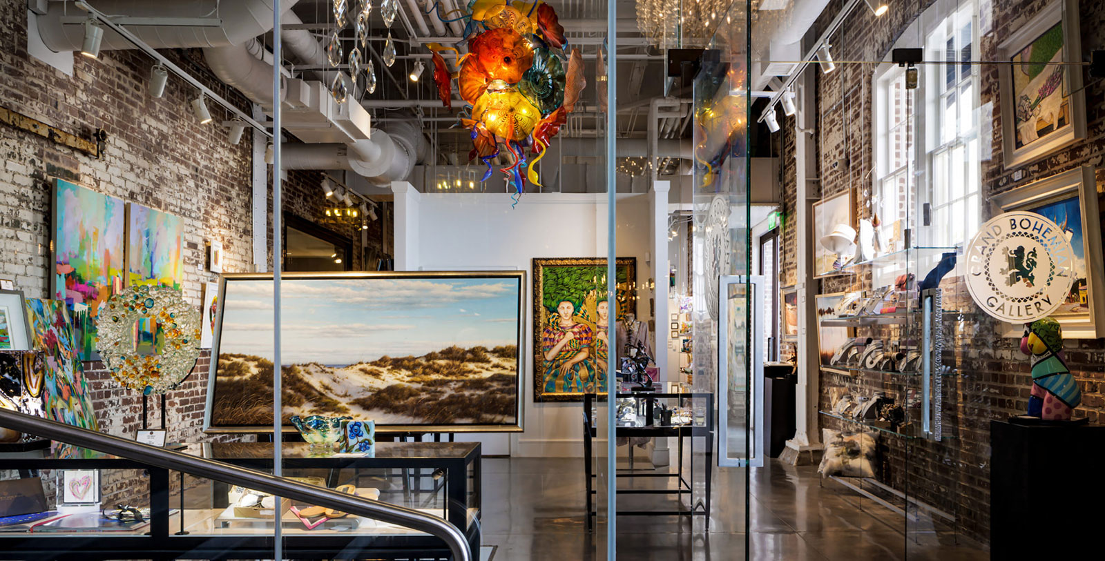 a glass wall with art from the ceiling
