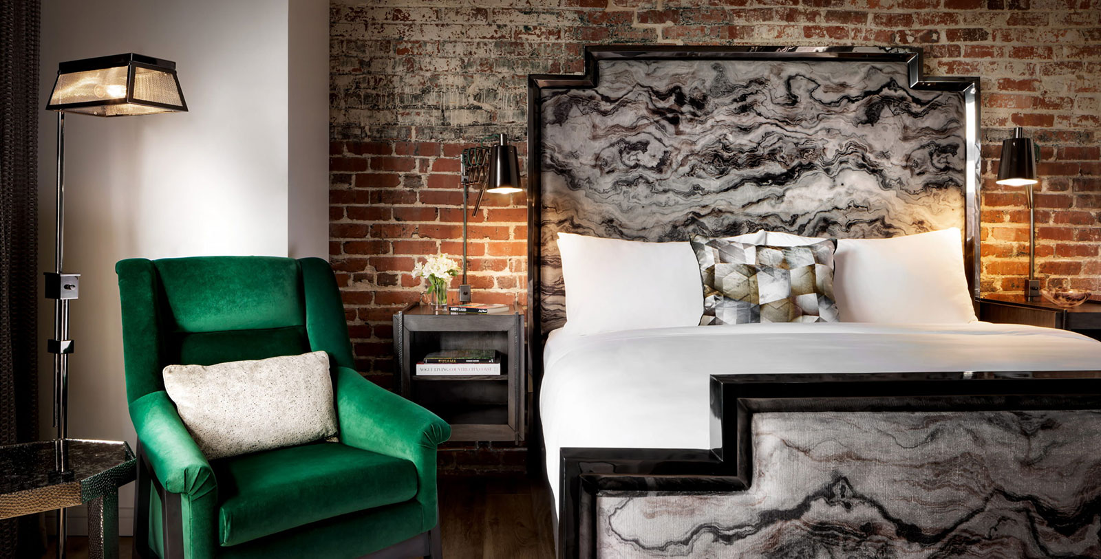 a bed with a green chair and a lamp