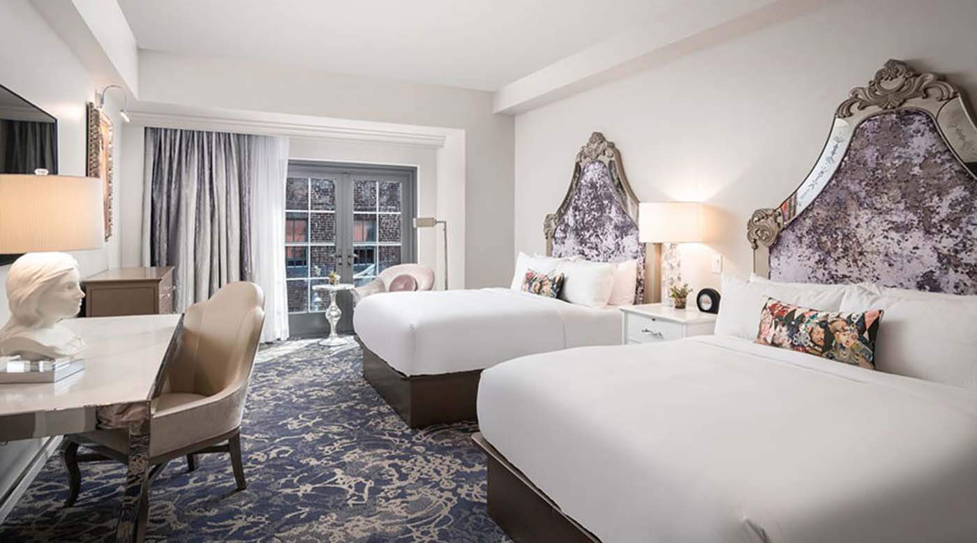 a room with two beds and a chair