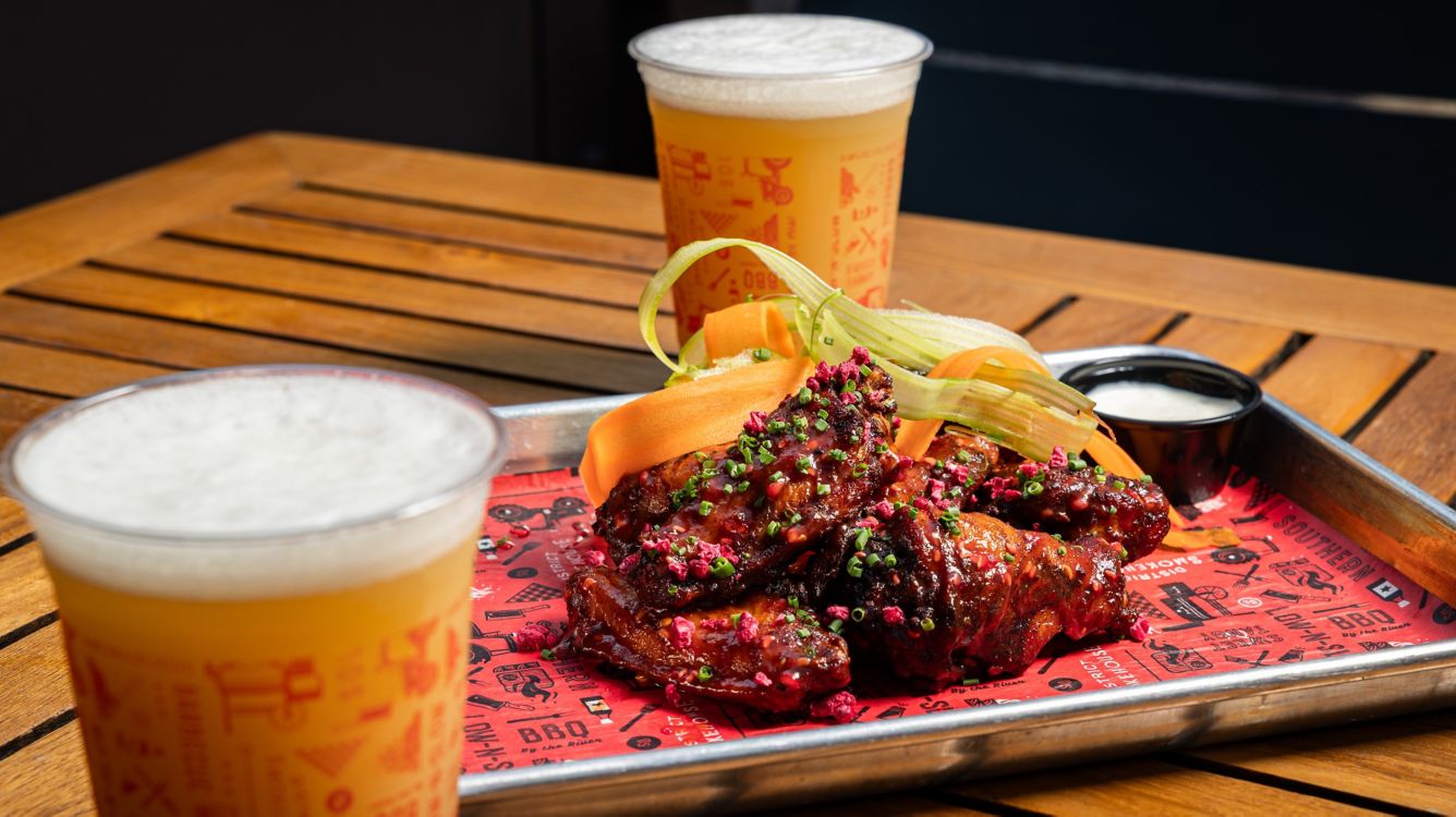a plate of chicken wings and beer