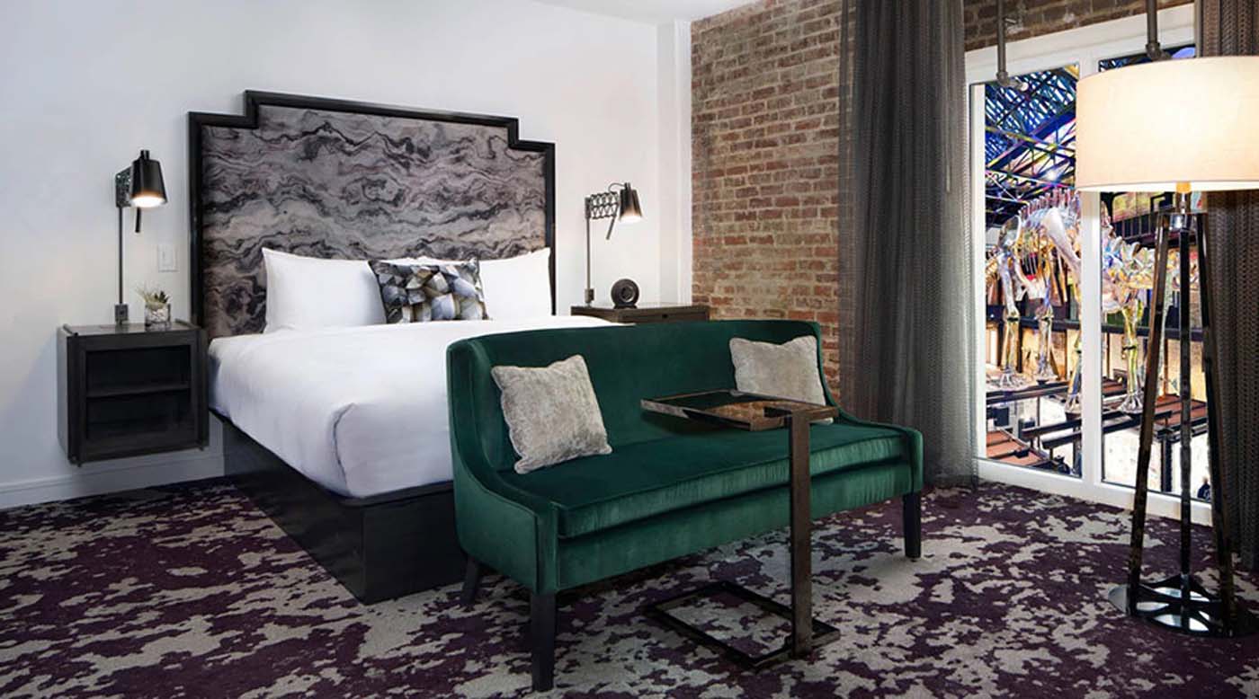 a green couch next to a bed
