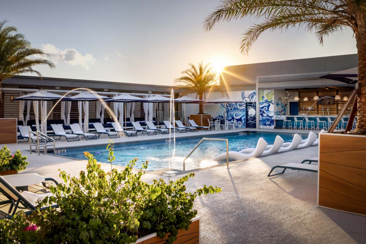 a pool with a fountain and chairs