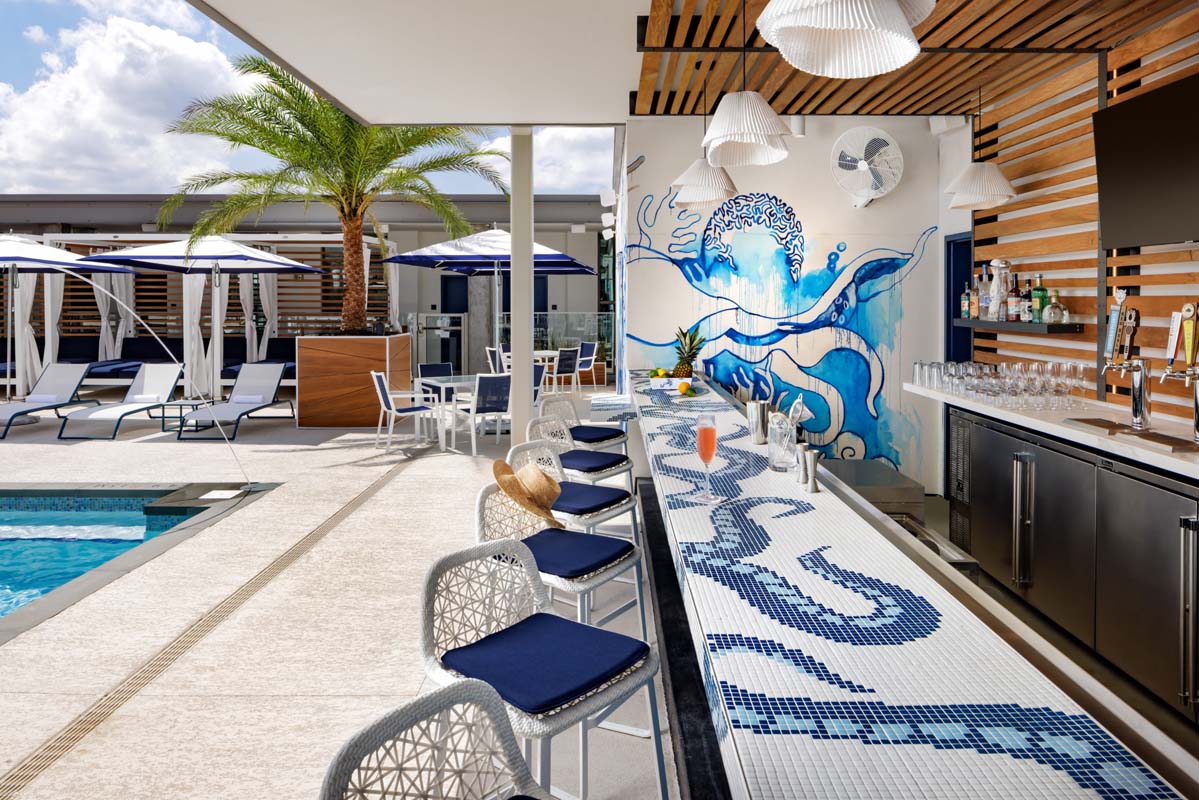 a bar with blue chairs and a pool