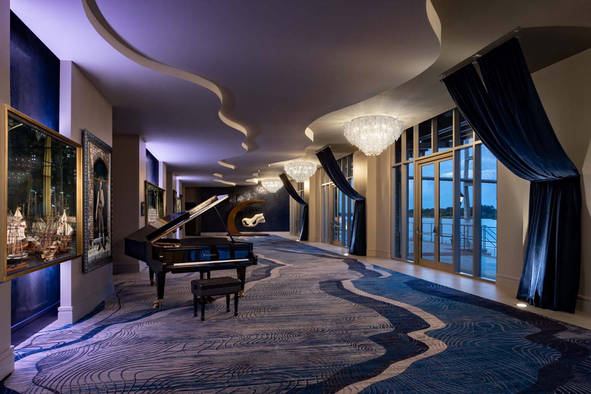 a room with a piano and chandeliers