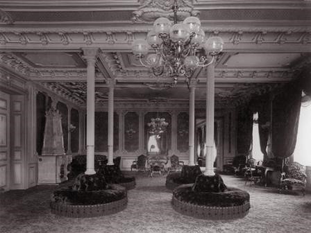 a room with chandelier and round tables