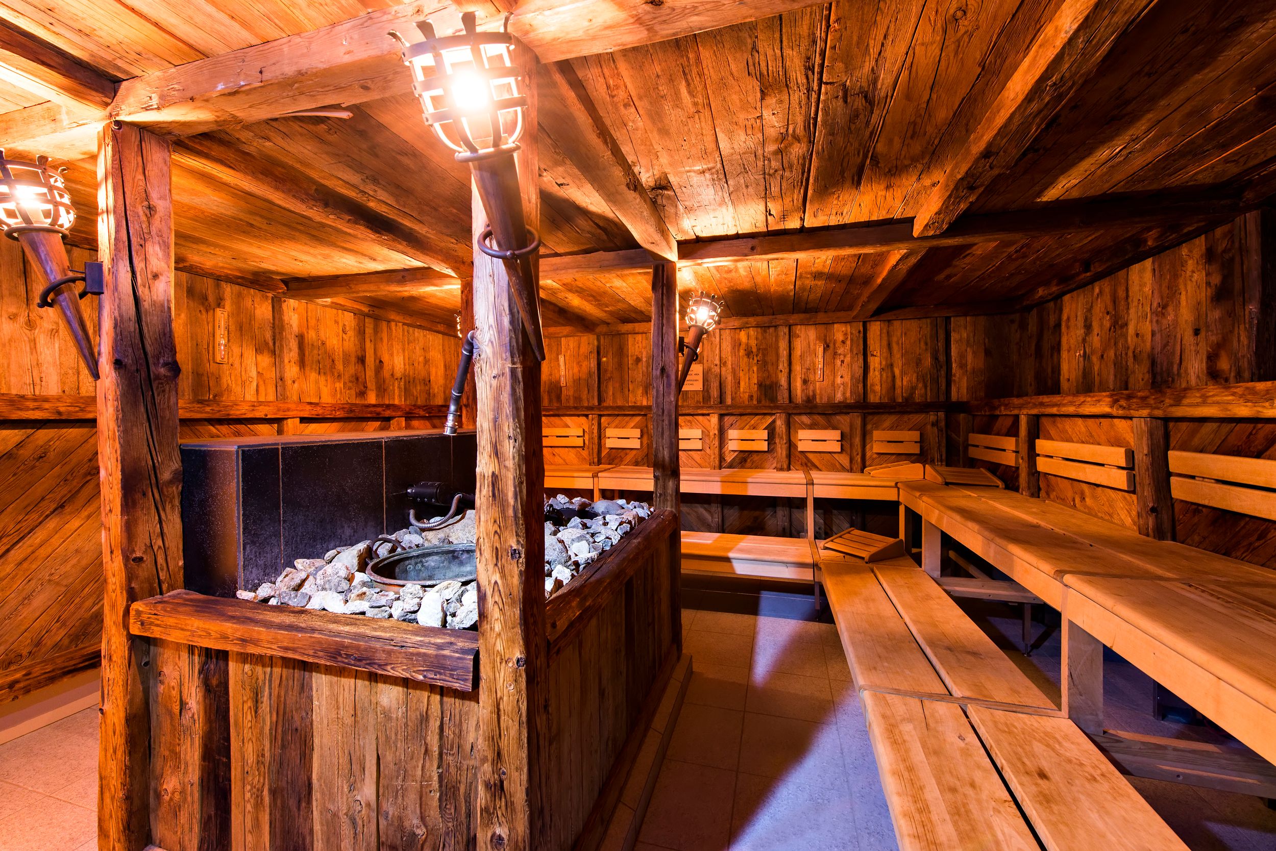 a wooden room with a hot tub and benches