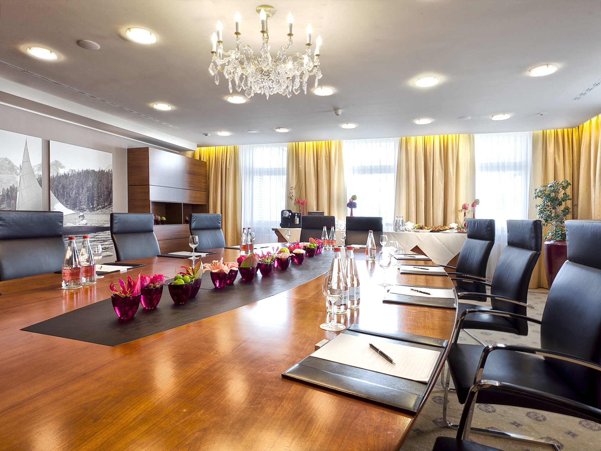 a conference room with a table with chairs and a chandelier