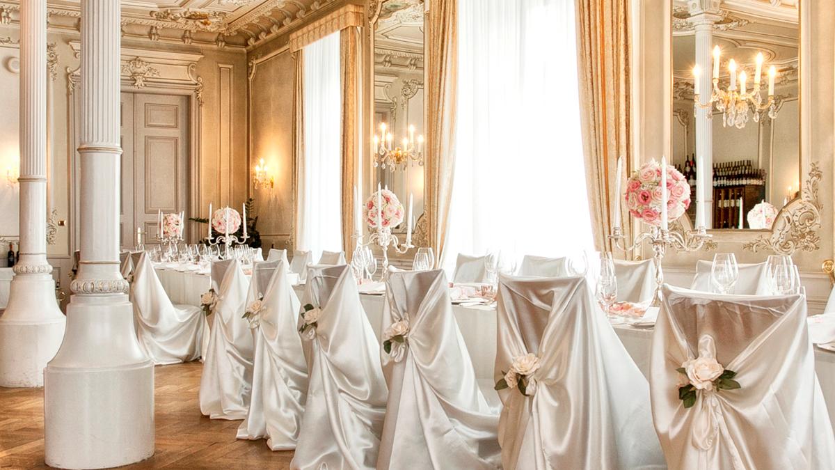 a room with tables and chairs covered in white cloth