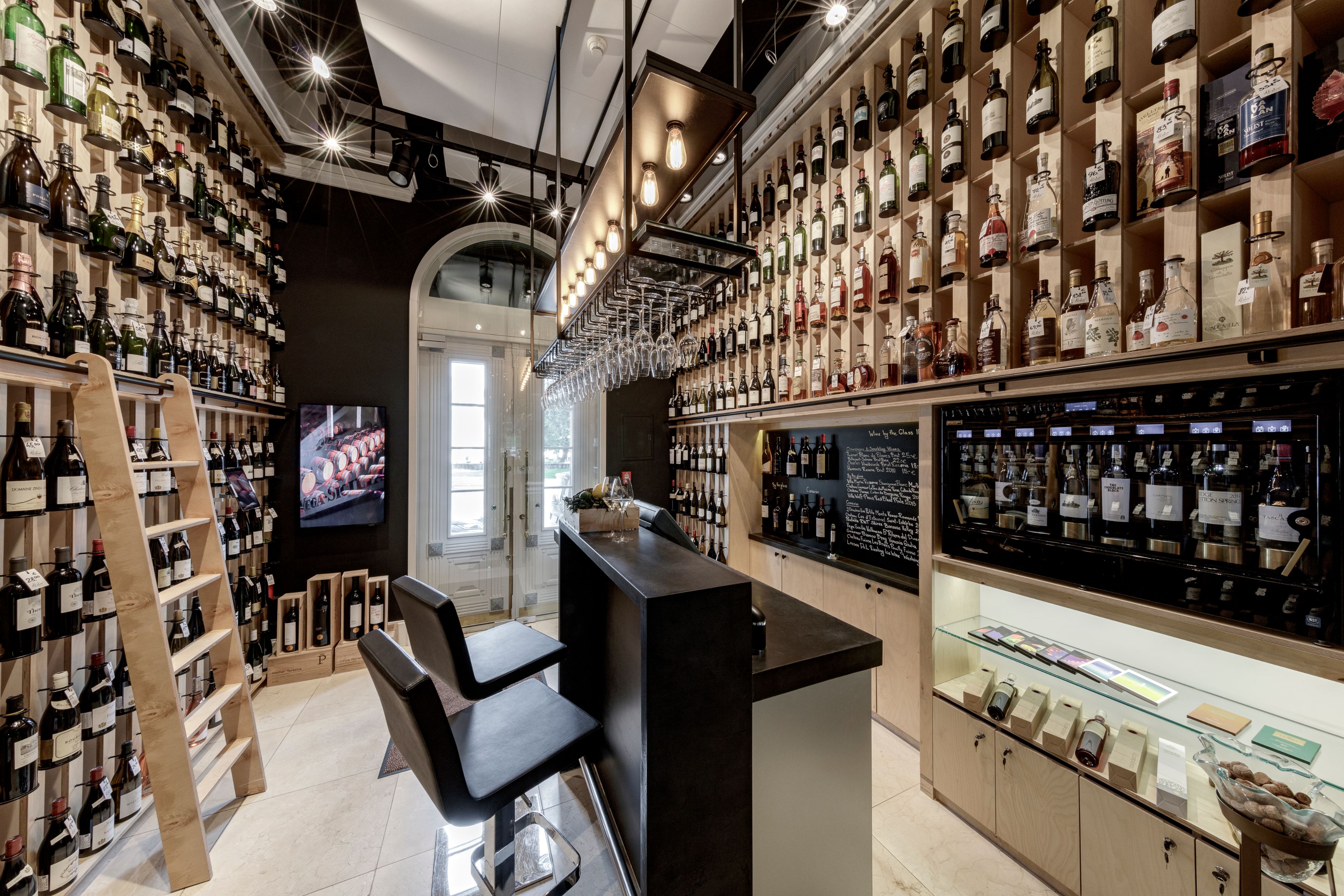 a room with shelves of liquor and chairs