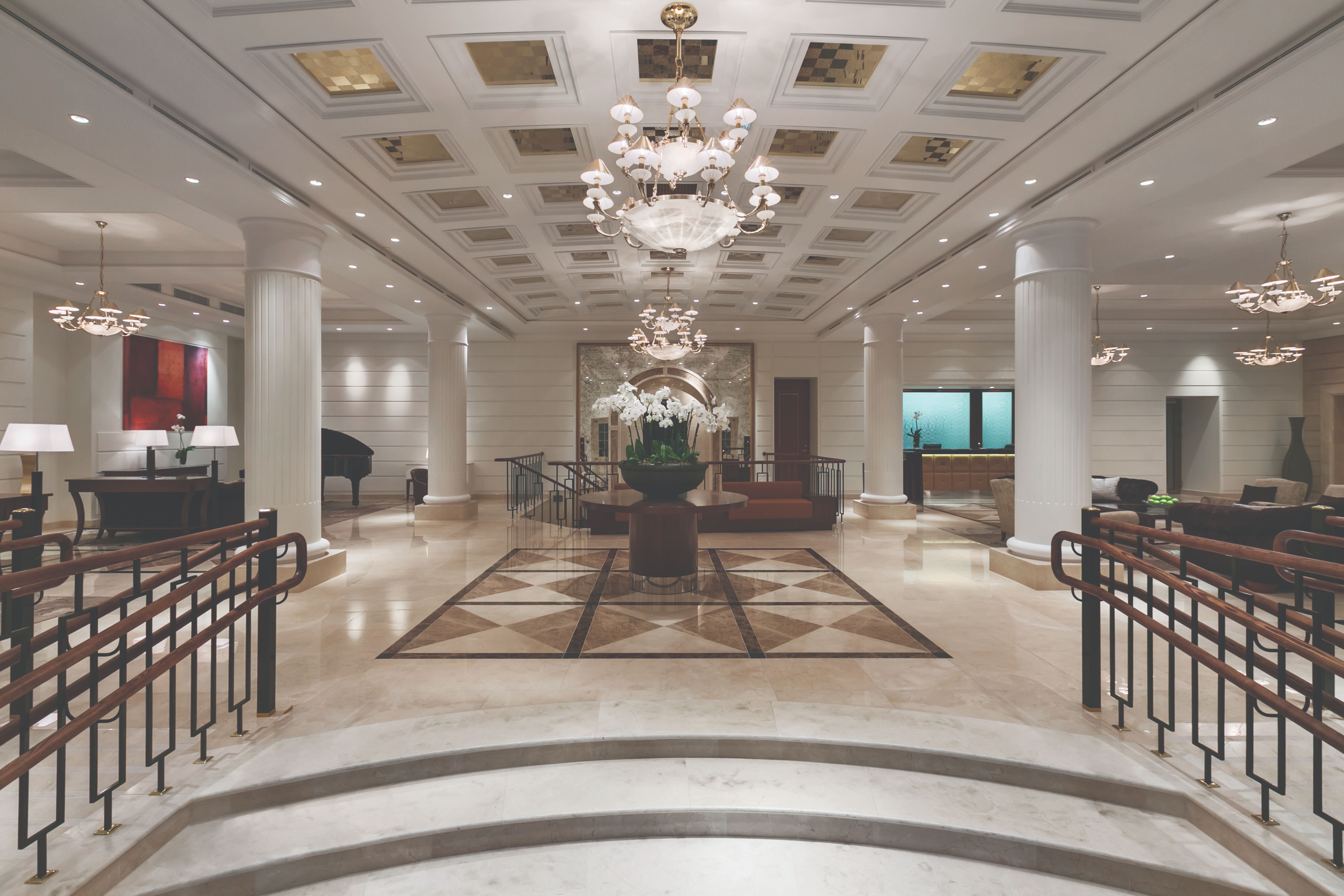 a large hall with stairs and chandeliers