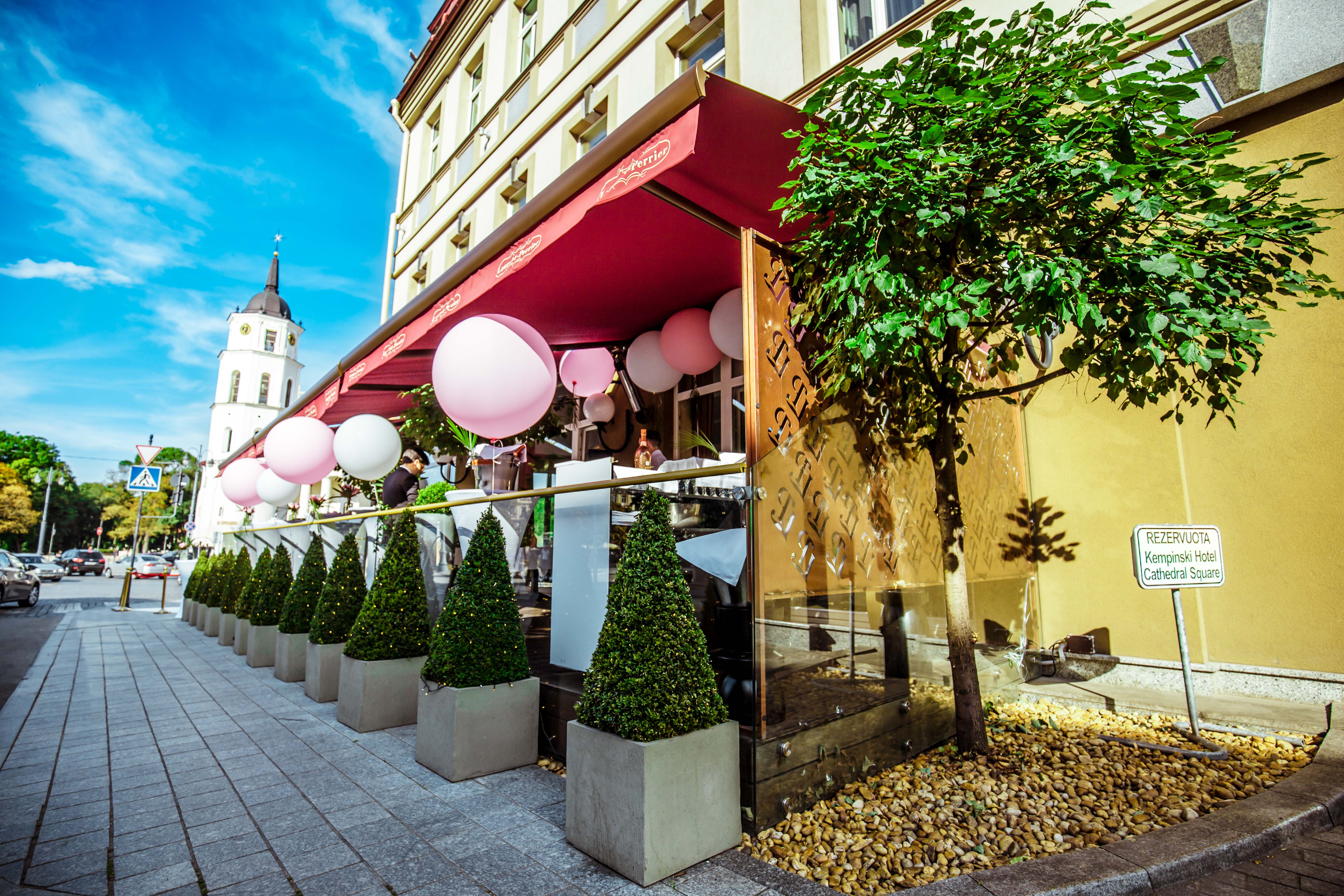 a building with a red awning and pink balloons