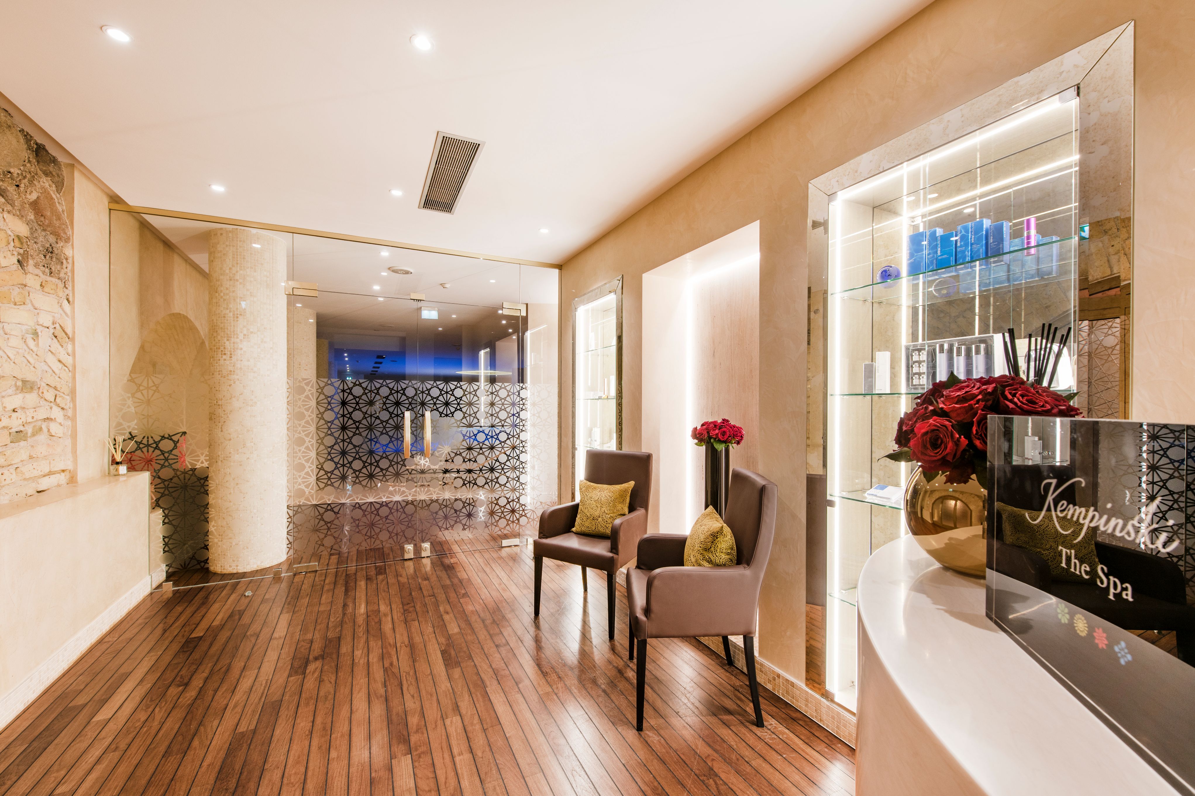 a room with chairs and vases in front of glass shelves