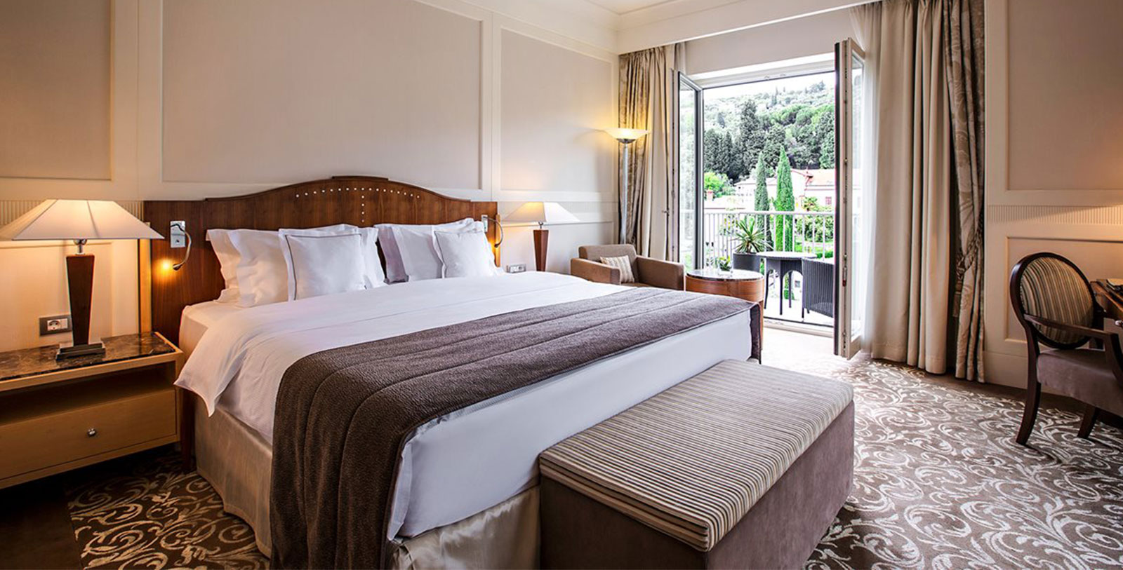 a bed with a bench and a chair in a hotel room