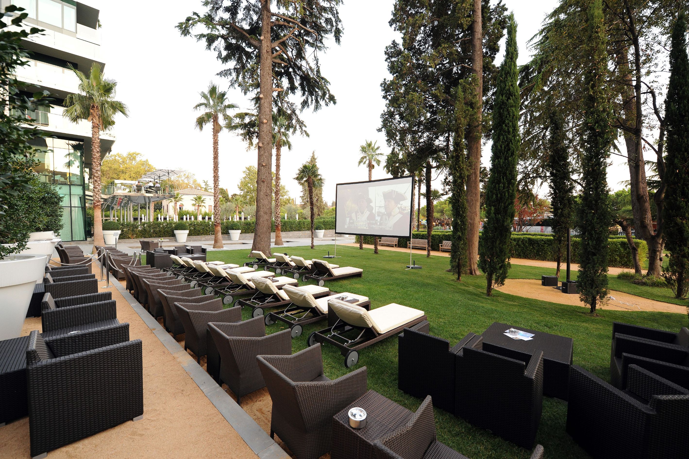 a outdoor movie theater with chairs and a projector screen