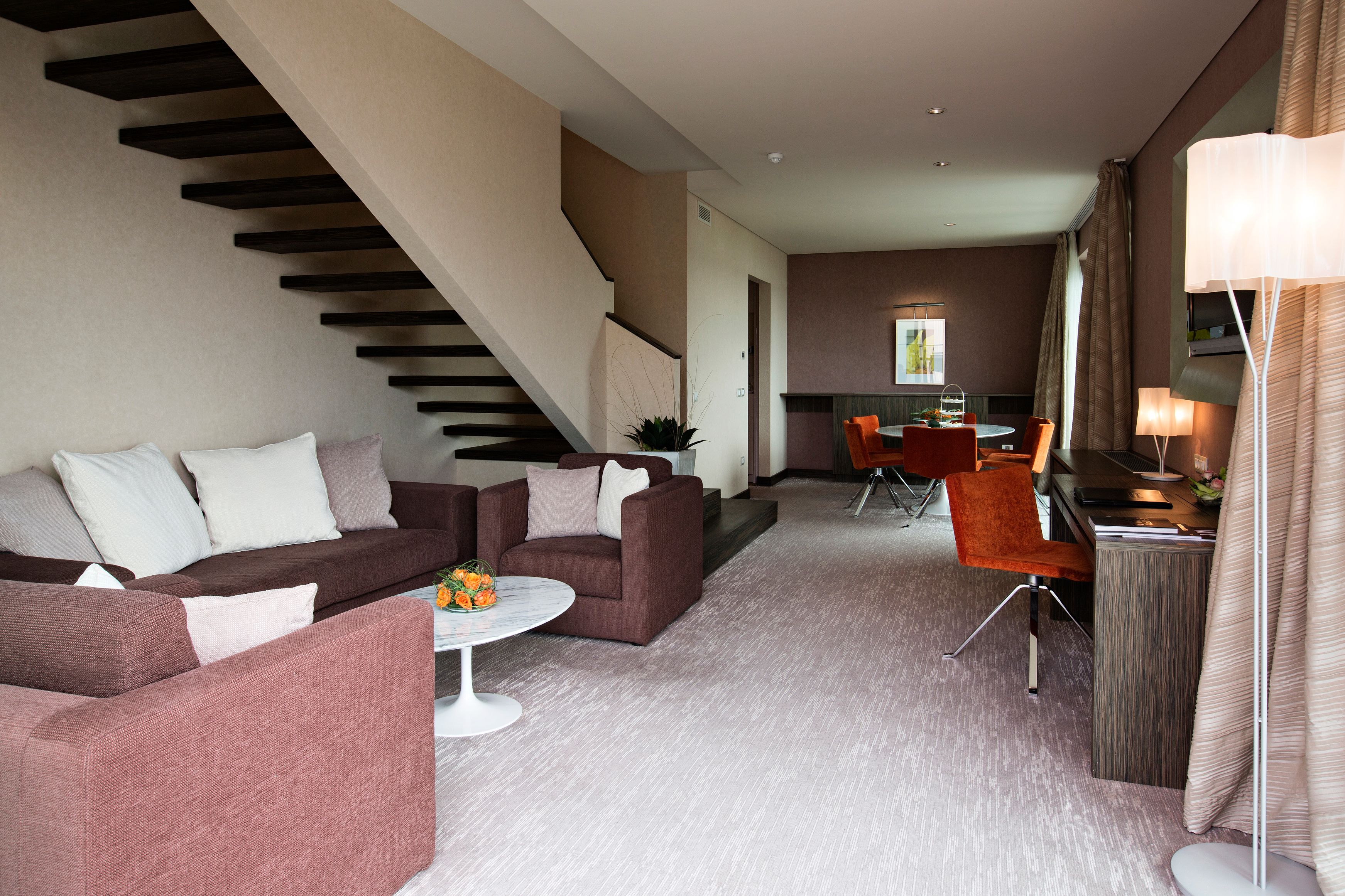 a living room with a staircase and couches