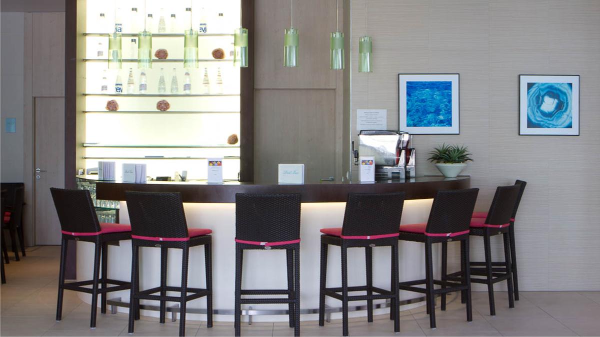 a bar with chairs in front of a counter