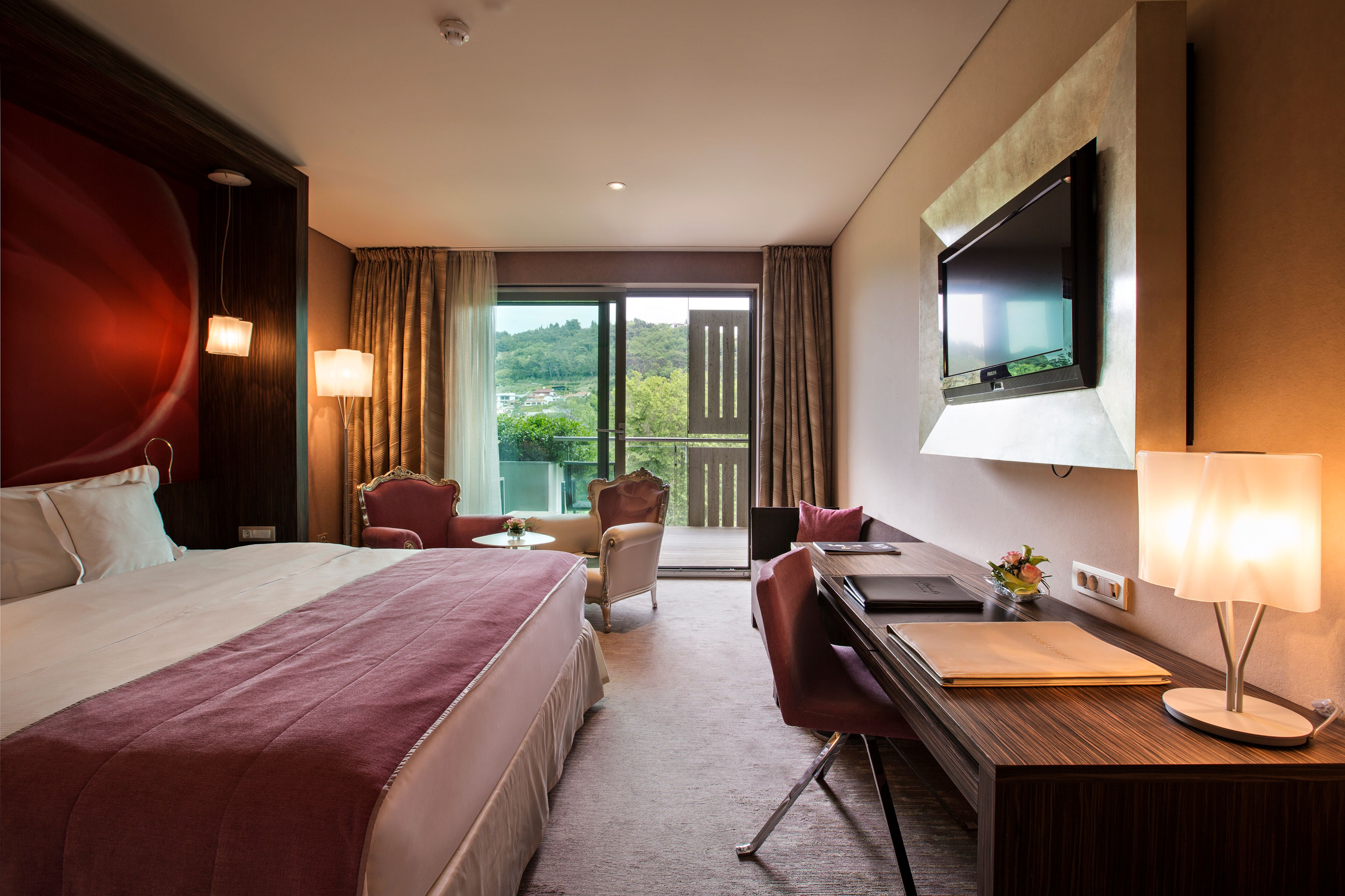 a room with a bed and a desk and a television