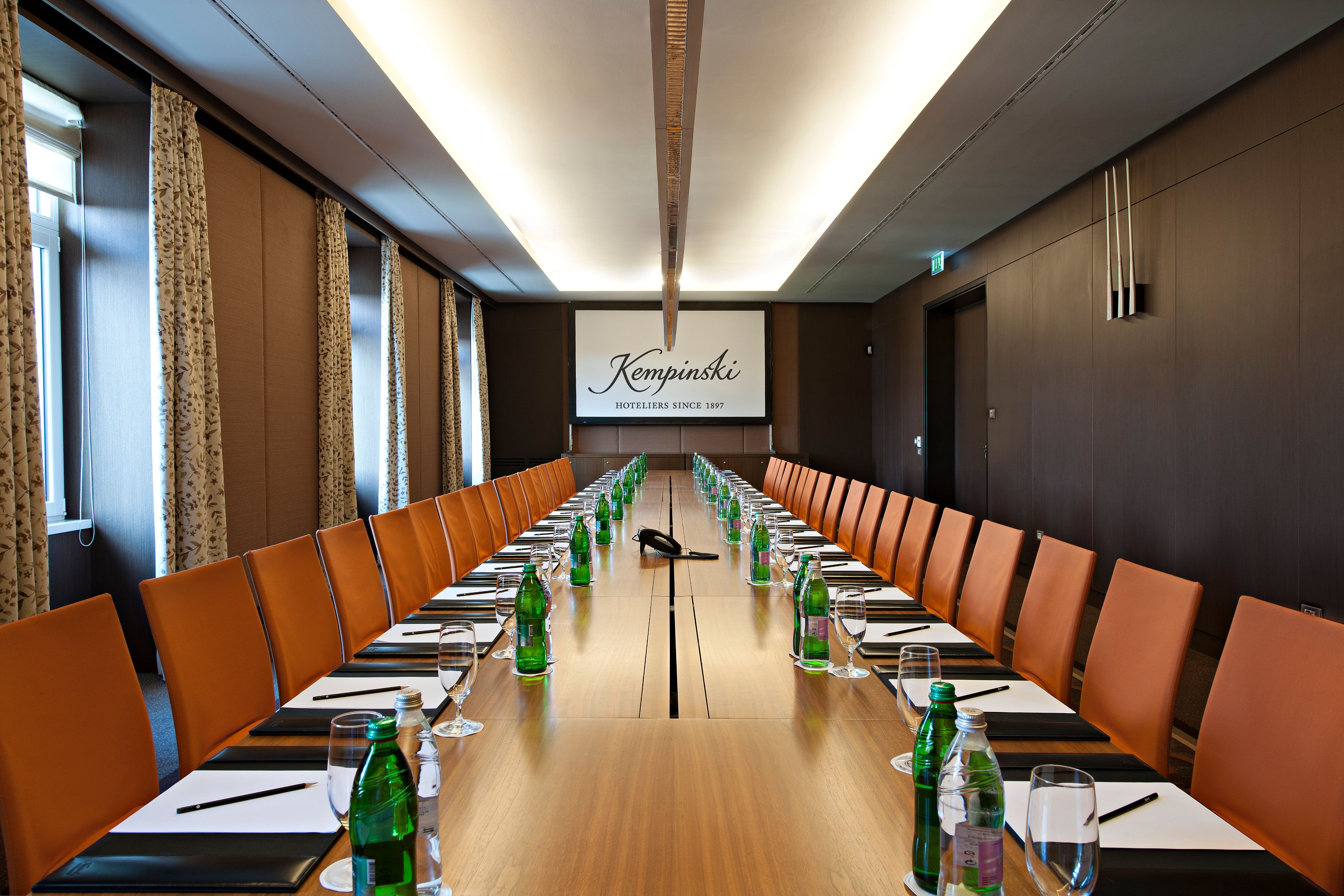a long conference table with empty glasses and bottles