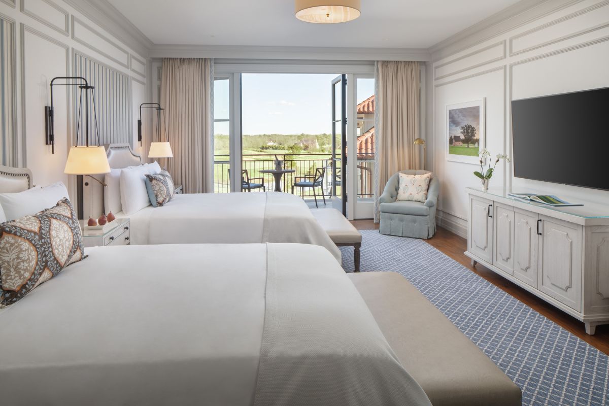 a room with two beds and a large glass door