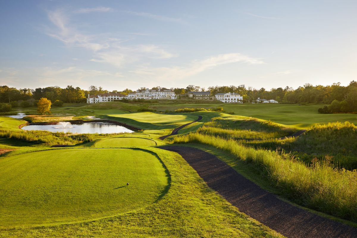 a golf course with a path and a lake