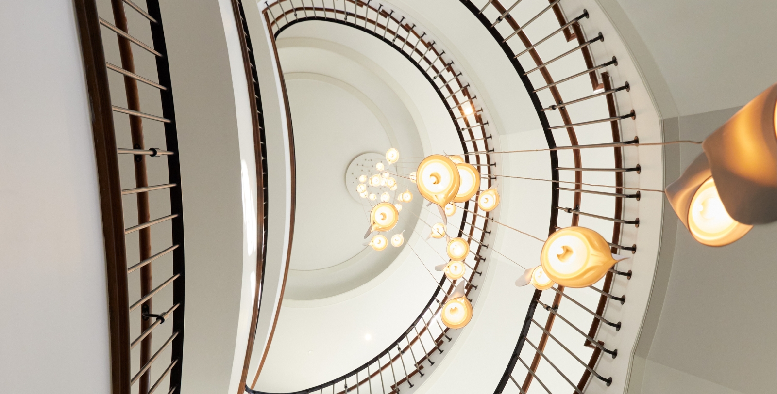 a spiral staircase with lights from the ceiling