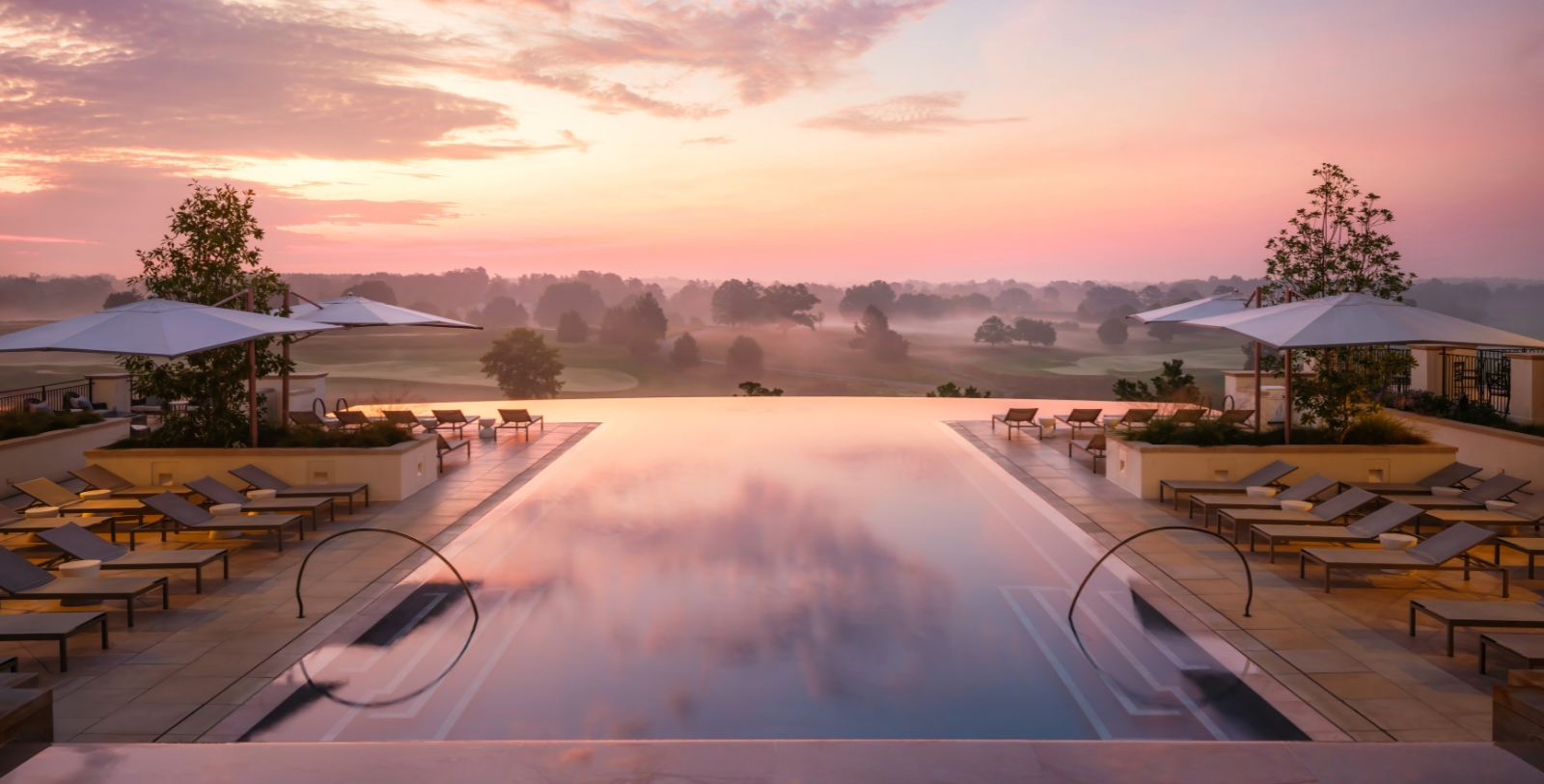 a pool with chairs and a view of a golf course