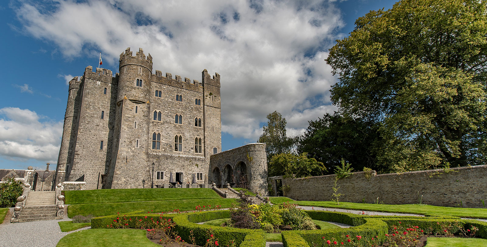 a castle with a garden and a blue sky