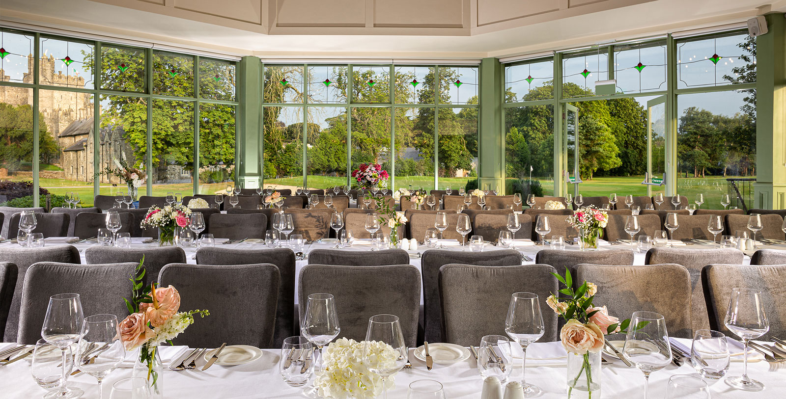 a room with tables and chairs and flowers