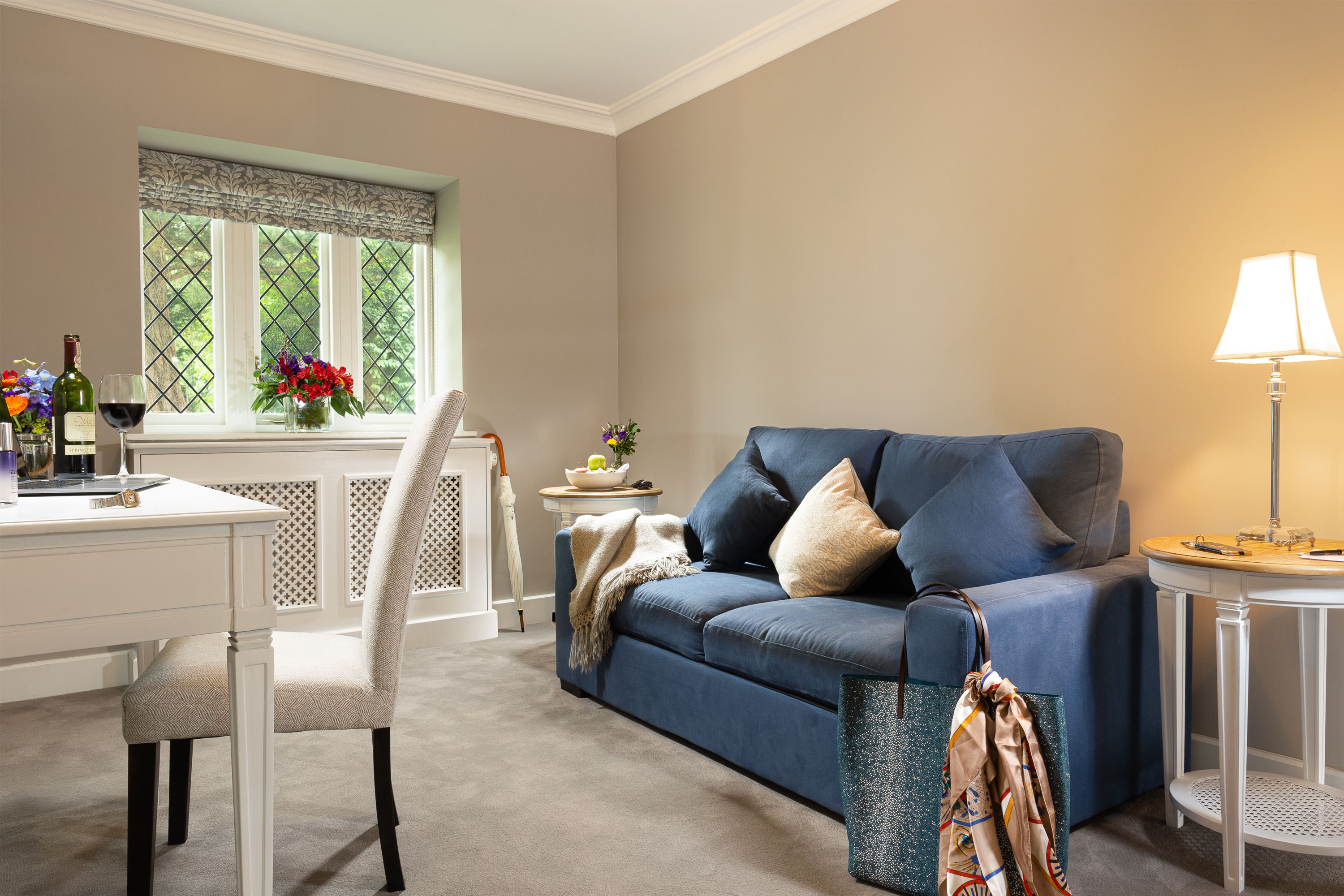 a living room with a blue couch and a white chair