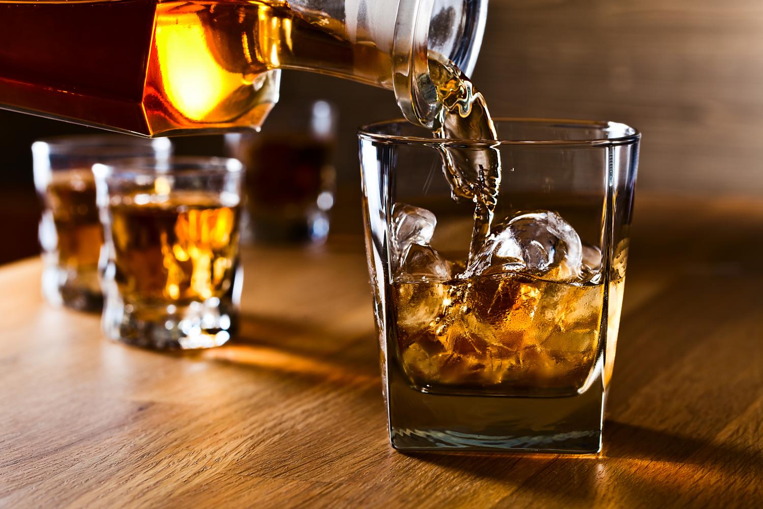 a glass of whiskey being poured into a glass
