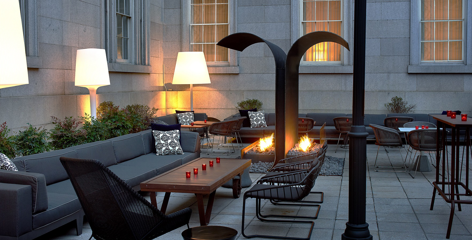 a patio with a fire pit and chairs