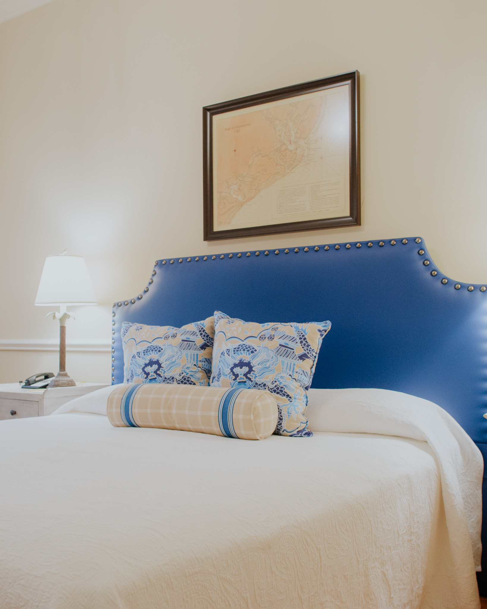 a bed with a blue headboard and a lamp