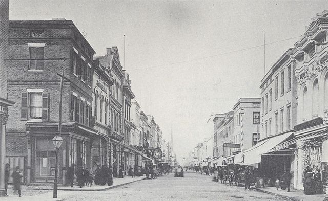 a street with buildings and horses