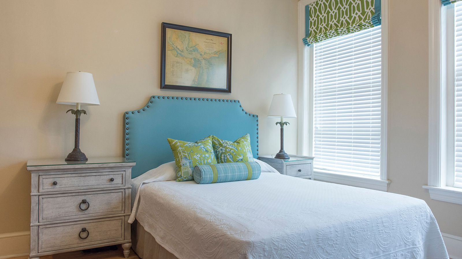 a bed with a blue headboard and a lamp