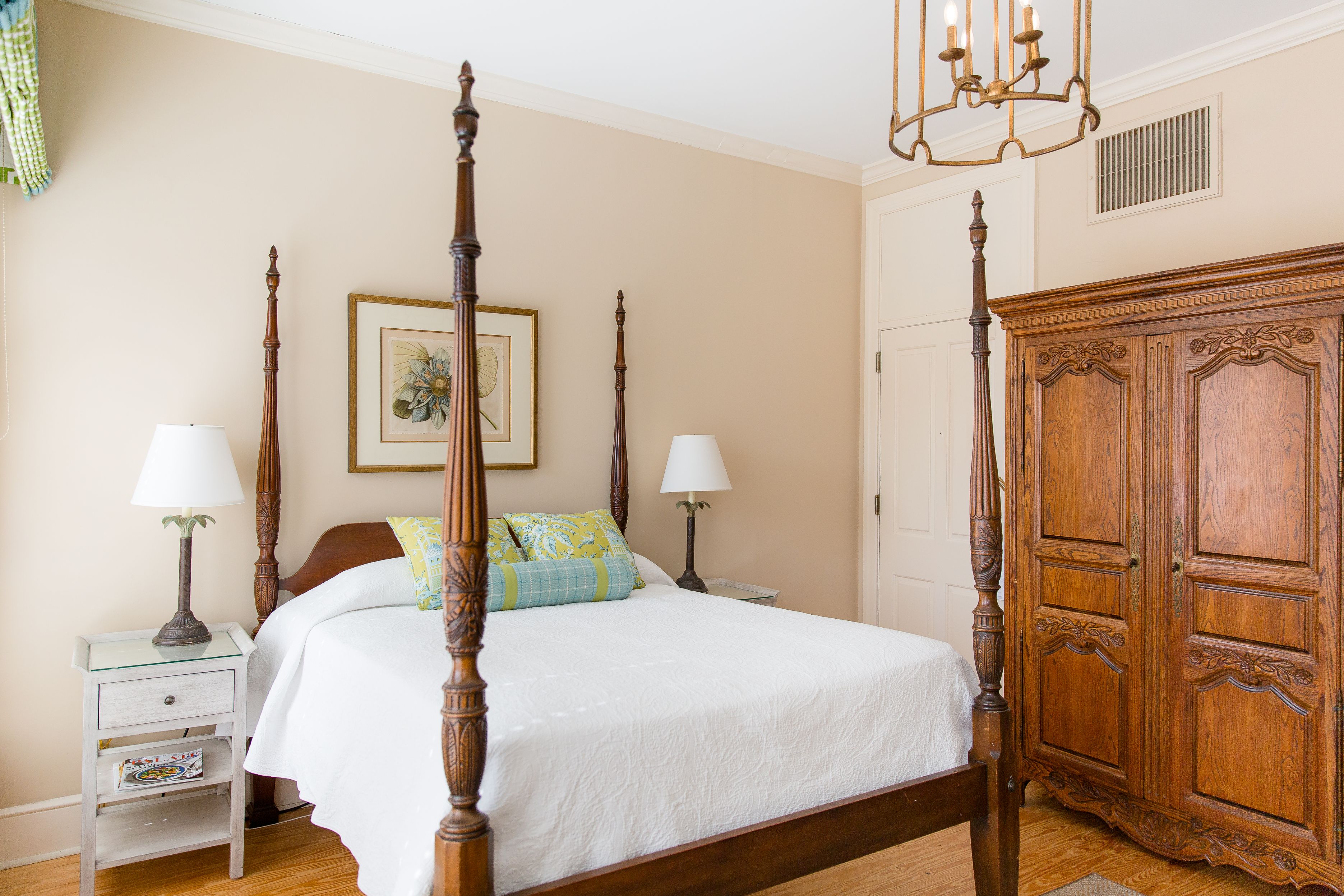 a bedroom with four poster bed and a chandelier