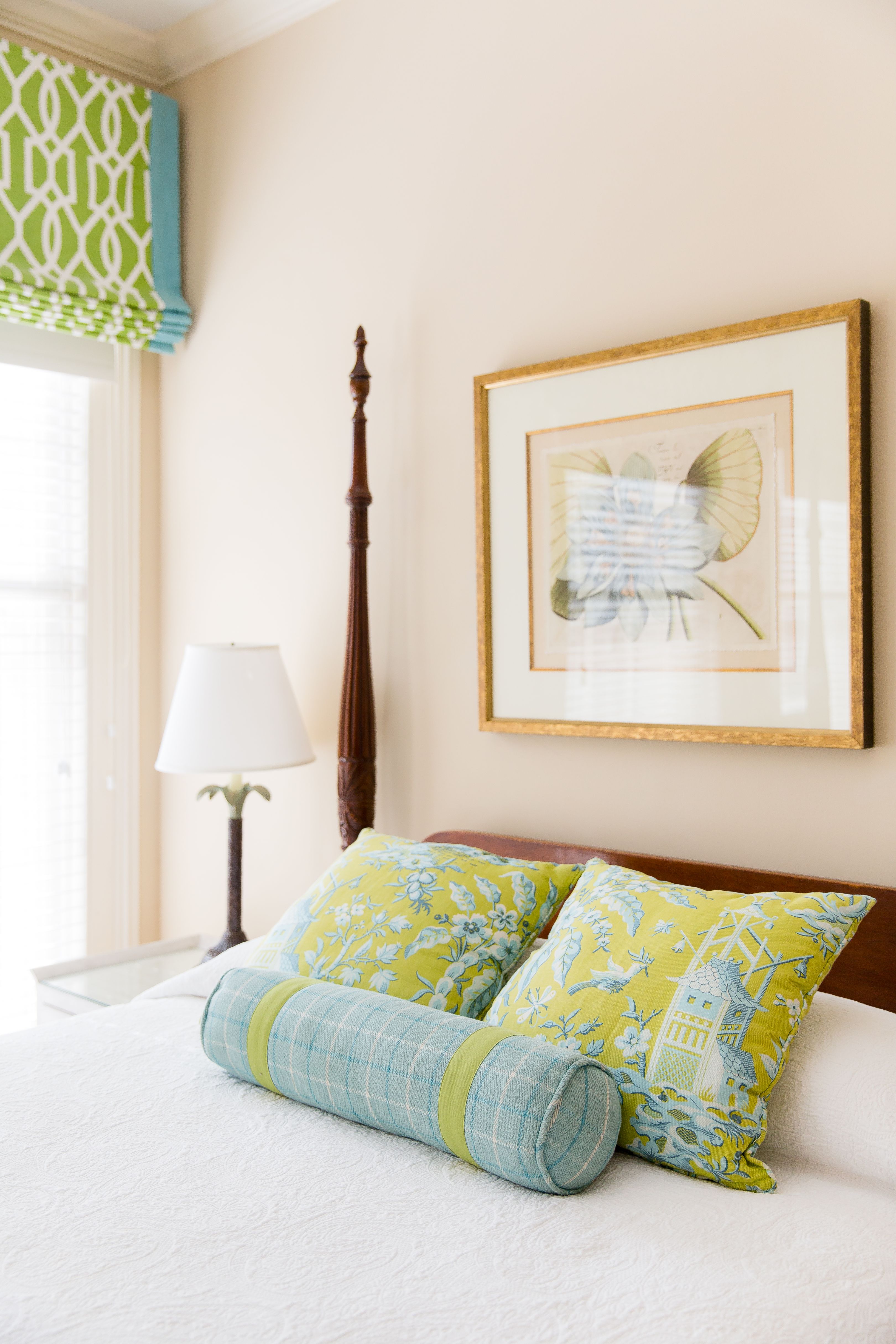 a bed with pillows and a picture on the wall