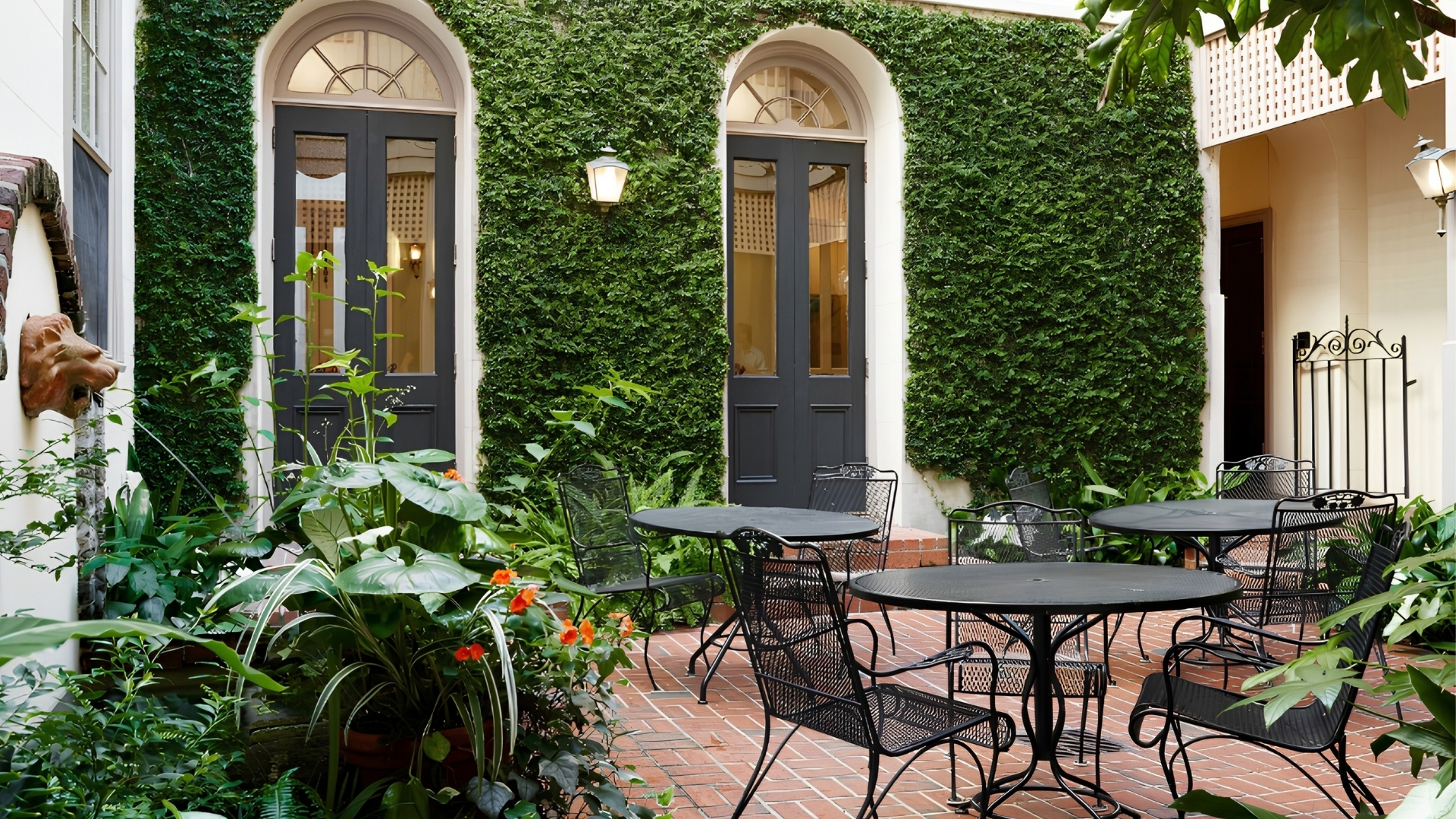 a patio with chairs and table in front of a building