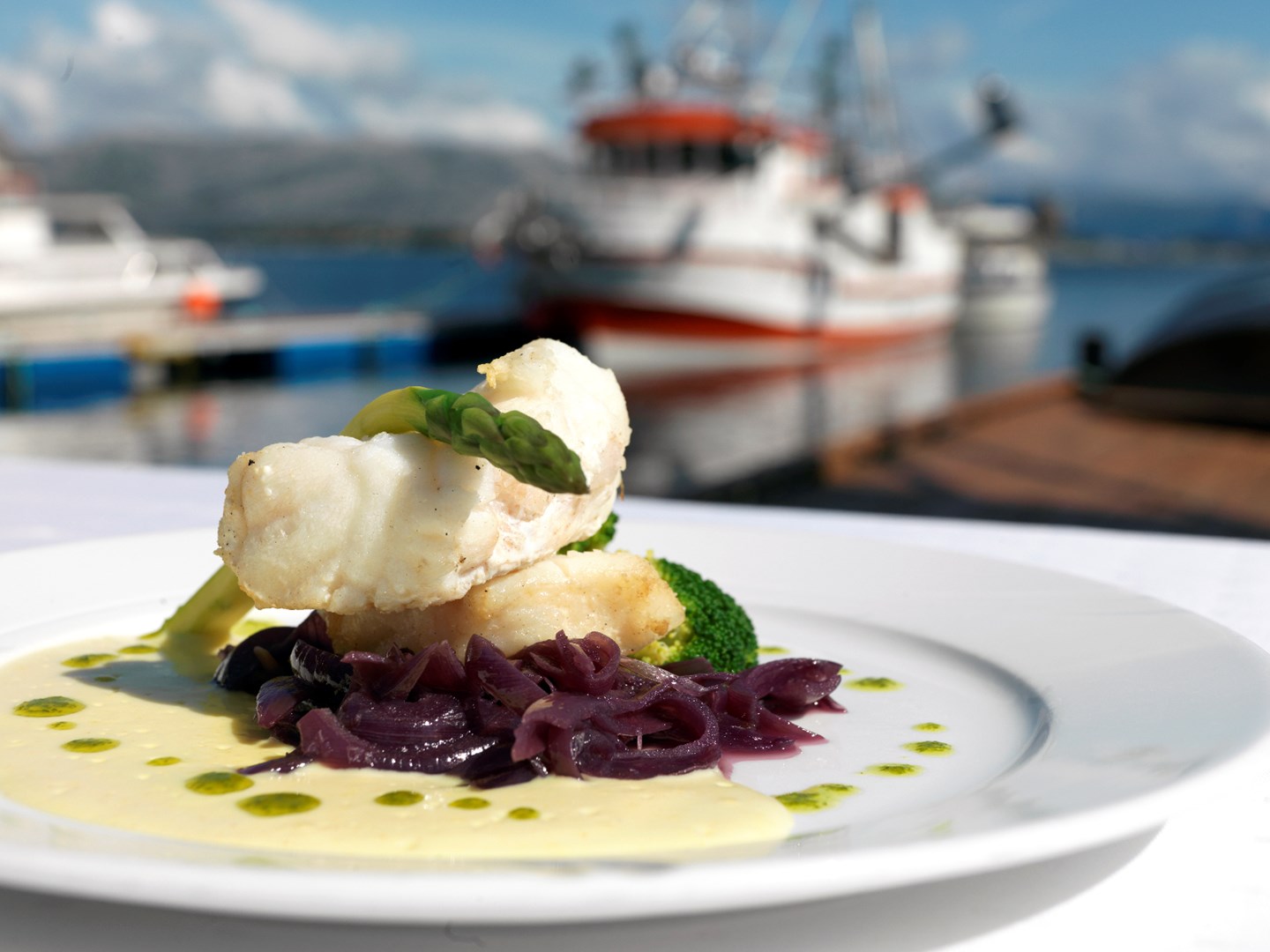 a plate of food with a boat in the background