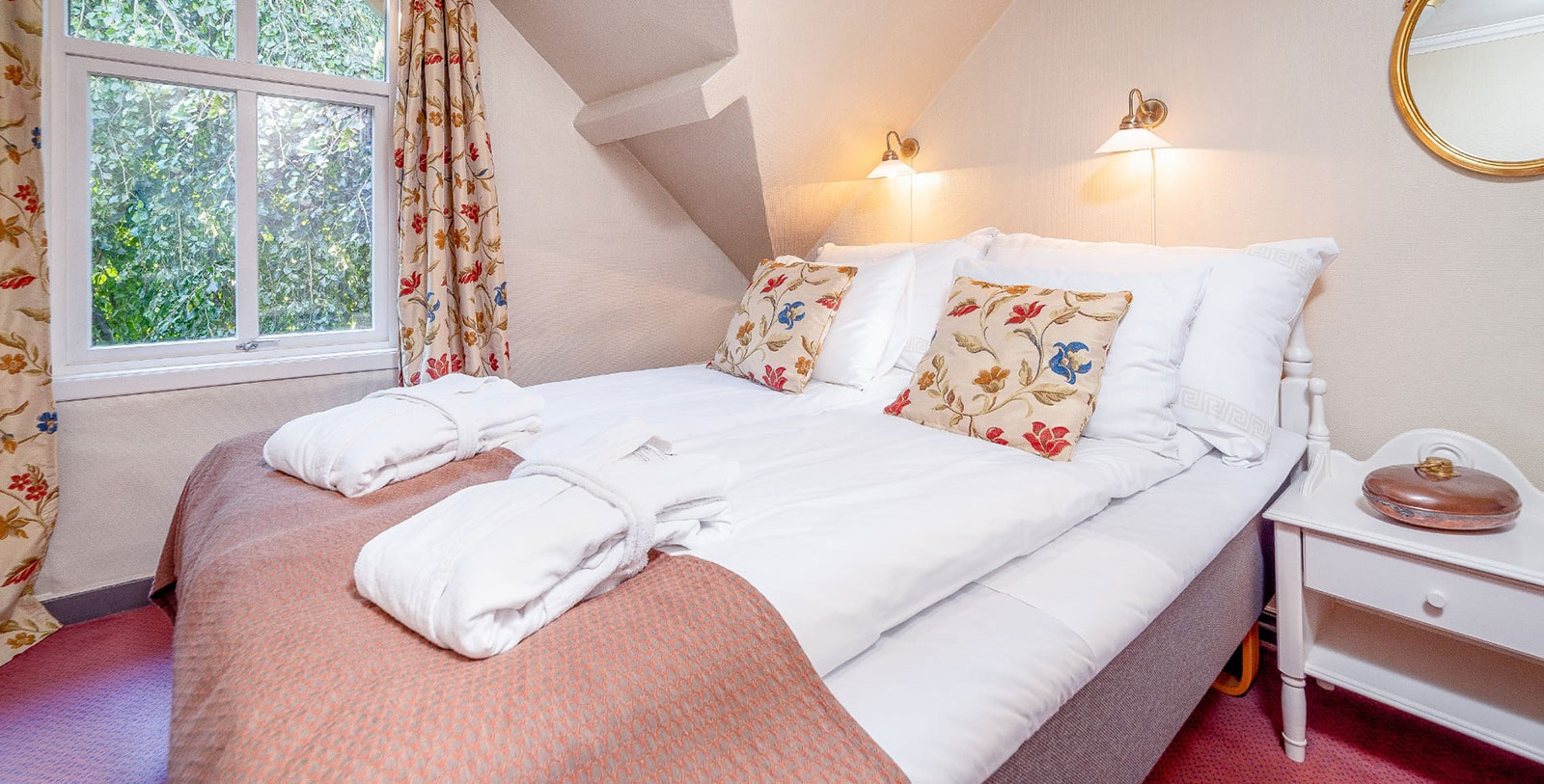 a bed with white sheets and pillows