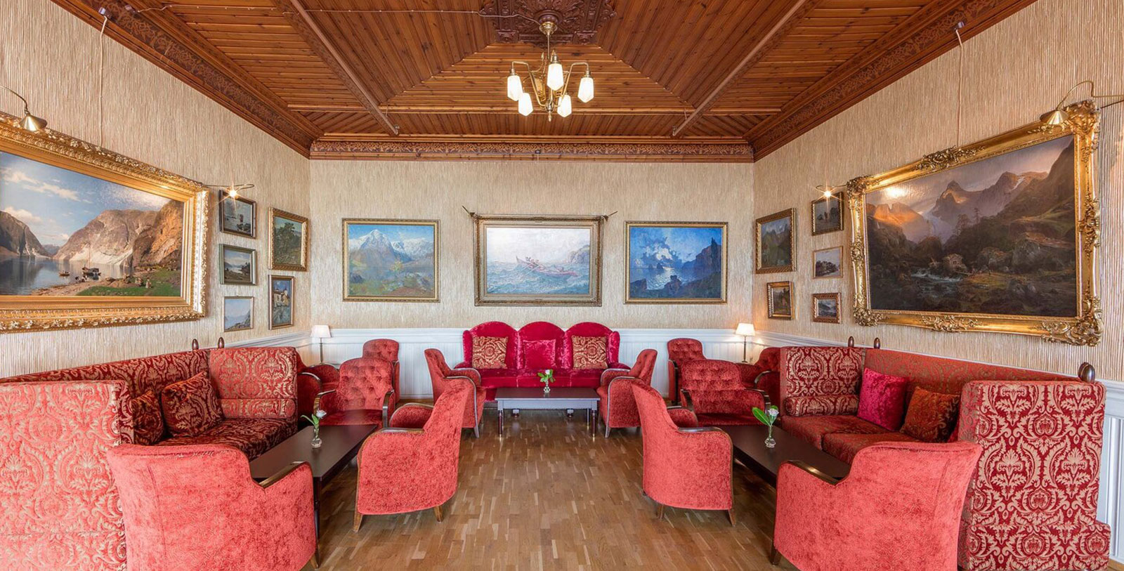 a room with red furniture and art on the wall