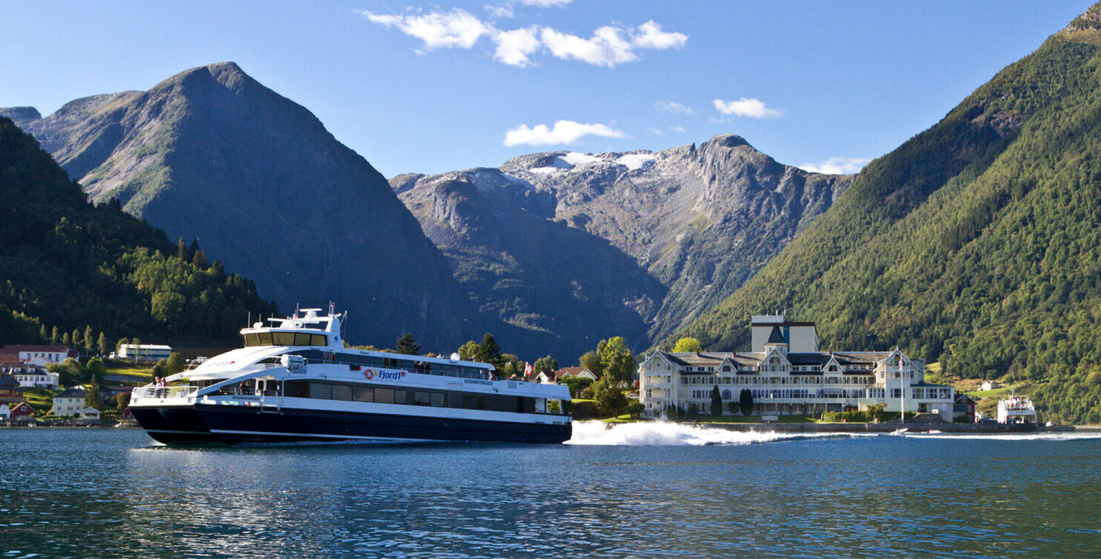 a boat on the water with Milford Sound in the background