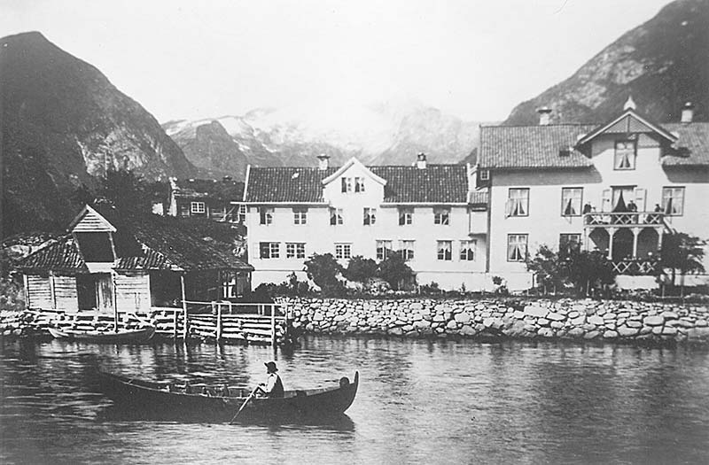 a boat in a river with a couple of houses in the background