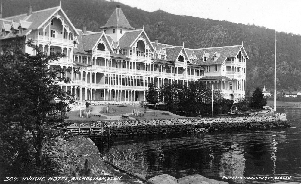 a large white building next to a body of water