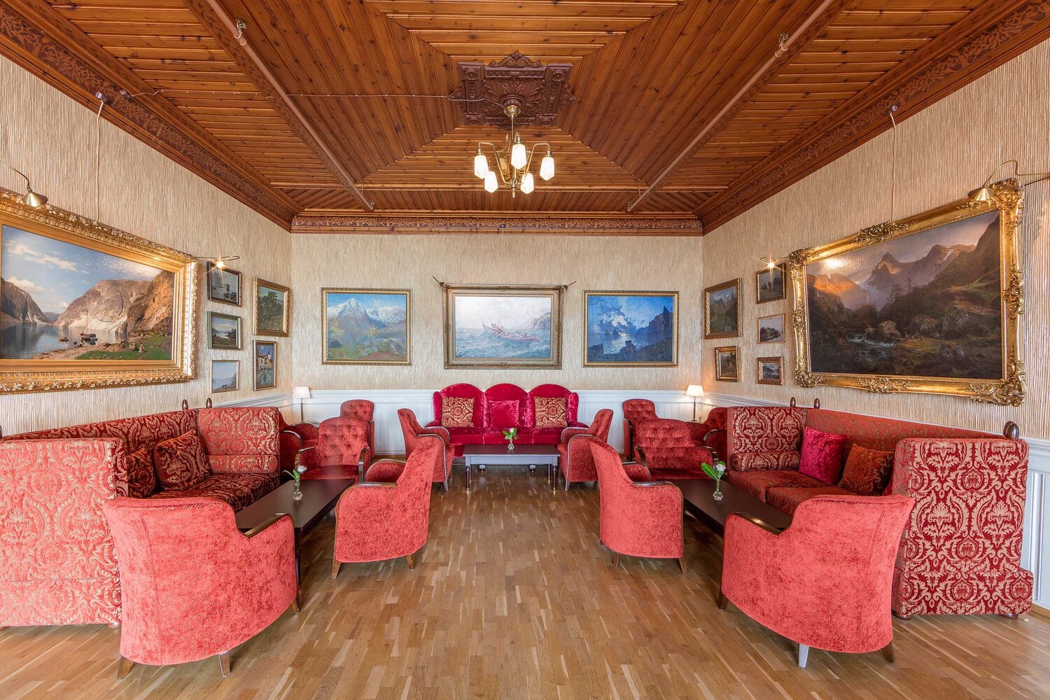 a room with red couches and pictures on the ceiling
