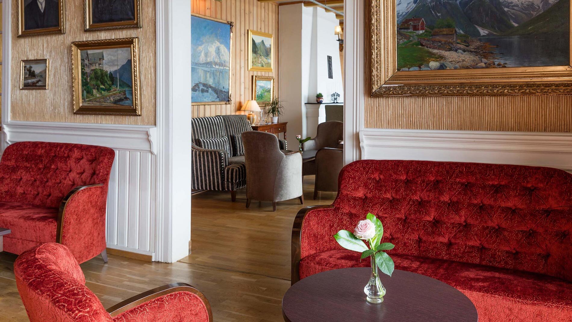 a room with red couches and paintings
