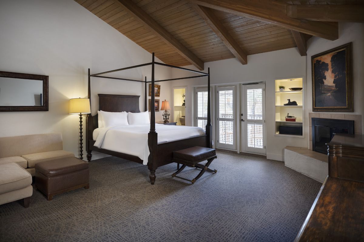 a bedroom with a four poster bed and a chair