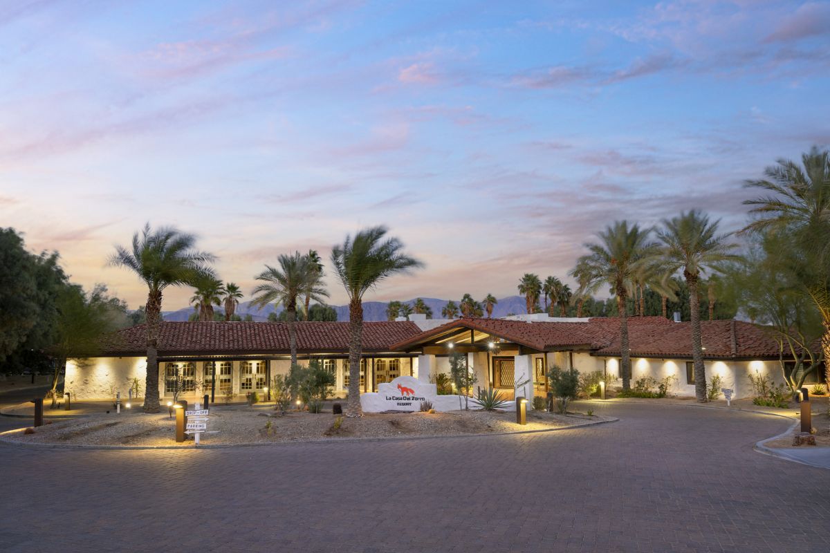 a building with palm trees and a sign
